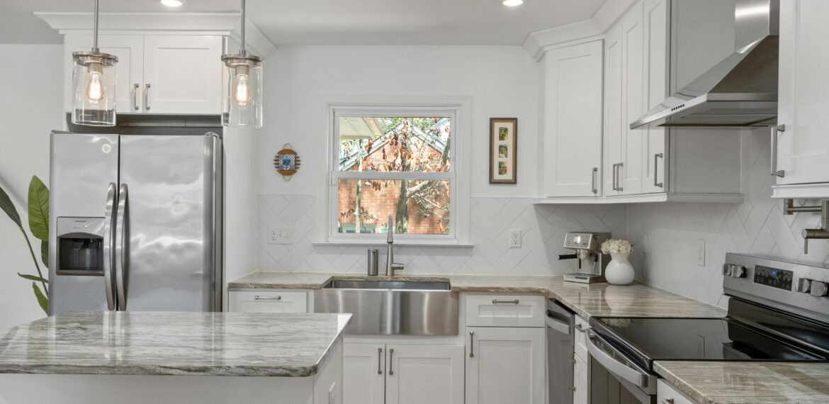 A contemporary kitchen with pristine white cabinets and polished stainless steel appliances, emphasizing a fresh and modern look.