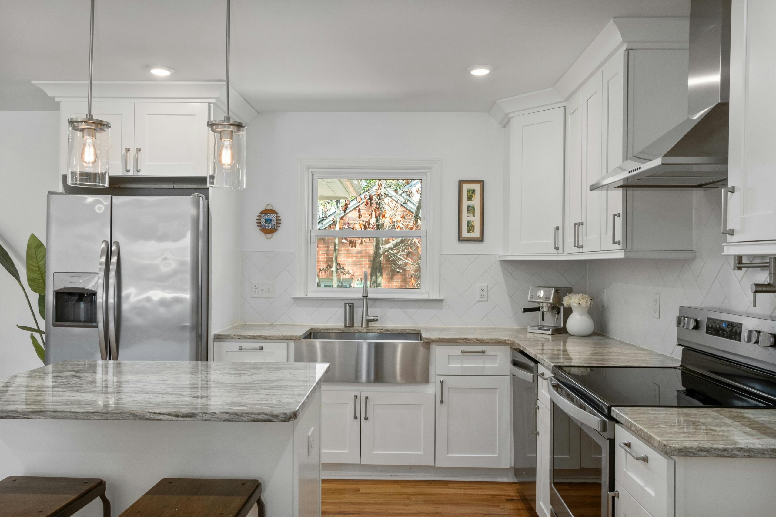 A contemporary kitchen with pristine white cabinets and polished stainless steel appliances, emphasizing a fresh and modern look.