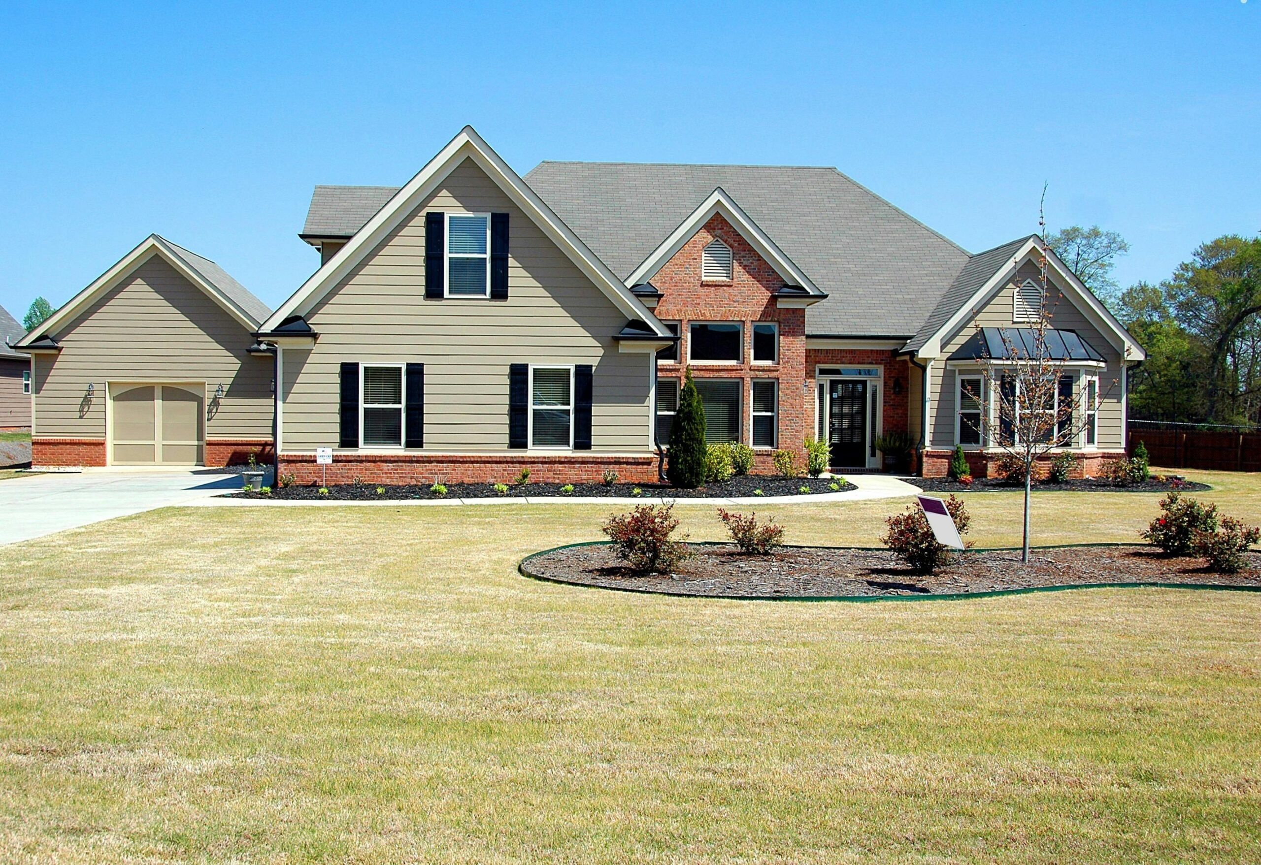 Spacious house with green lawn in front.