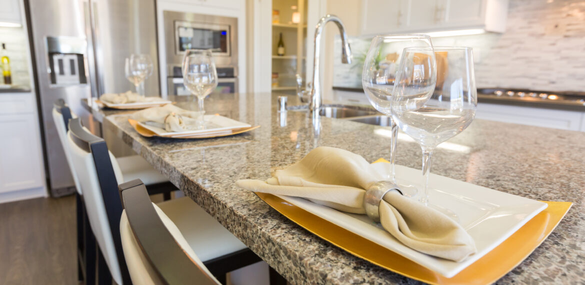 Organized glasses of wine and plates on countertops.