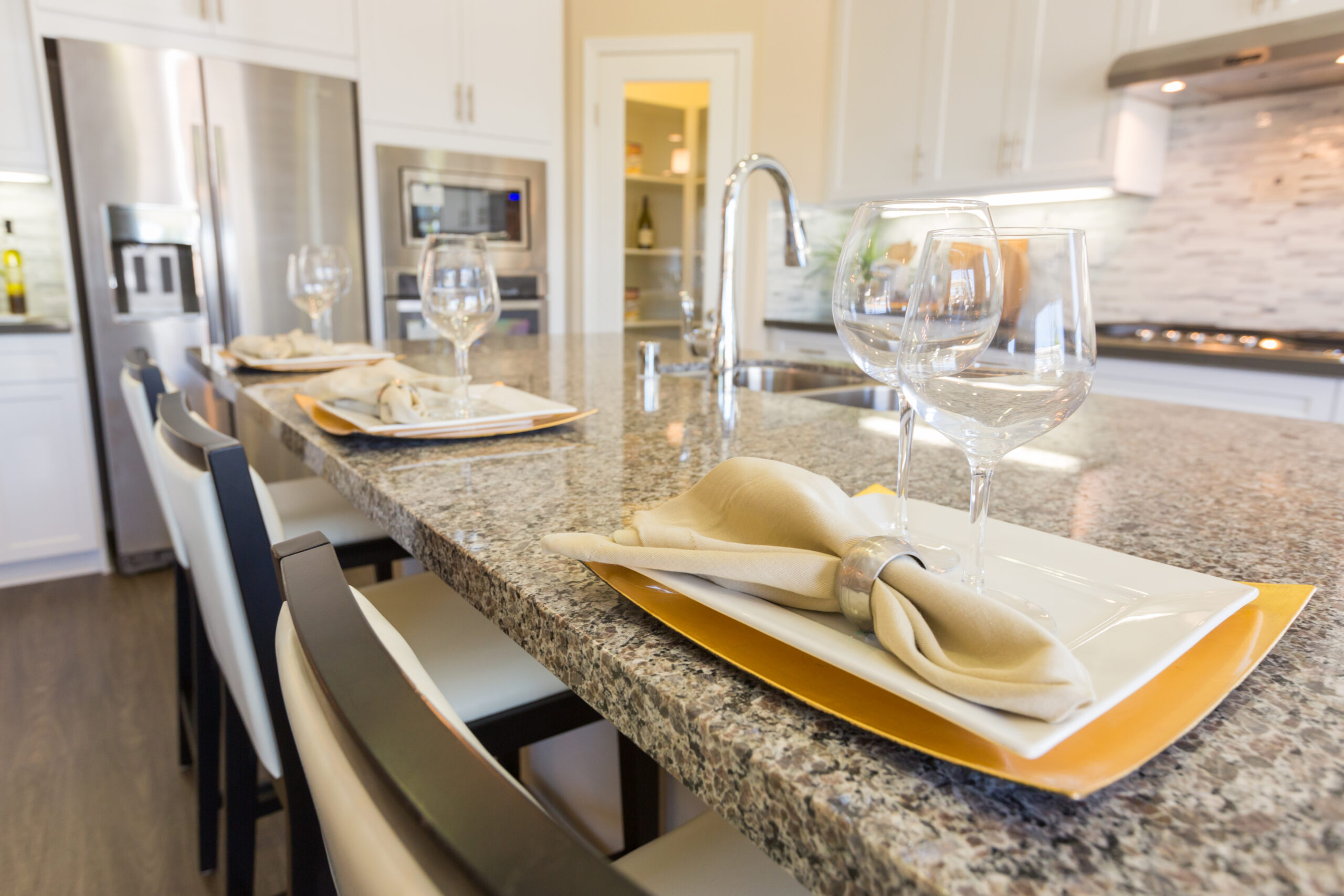 Organized glasses of wine and plates on countertops.