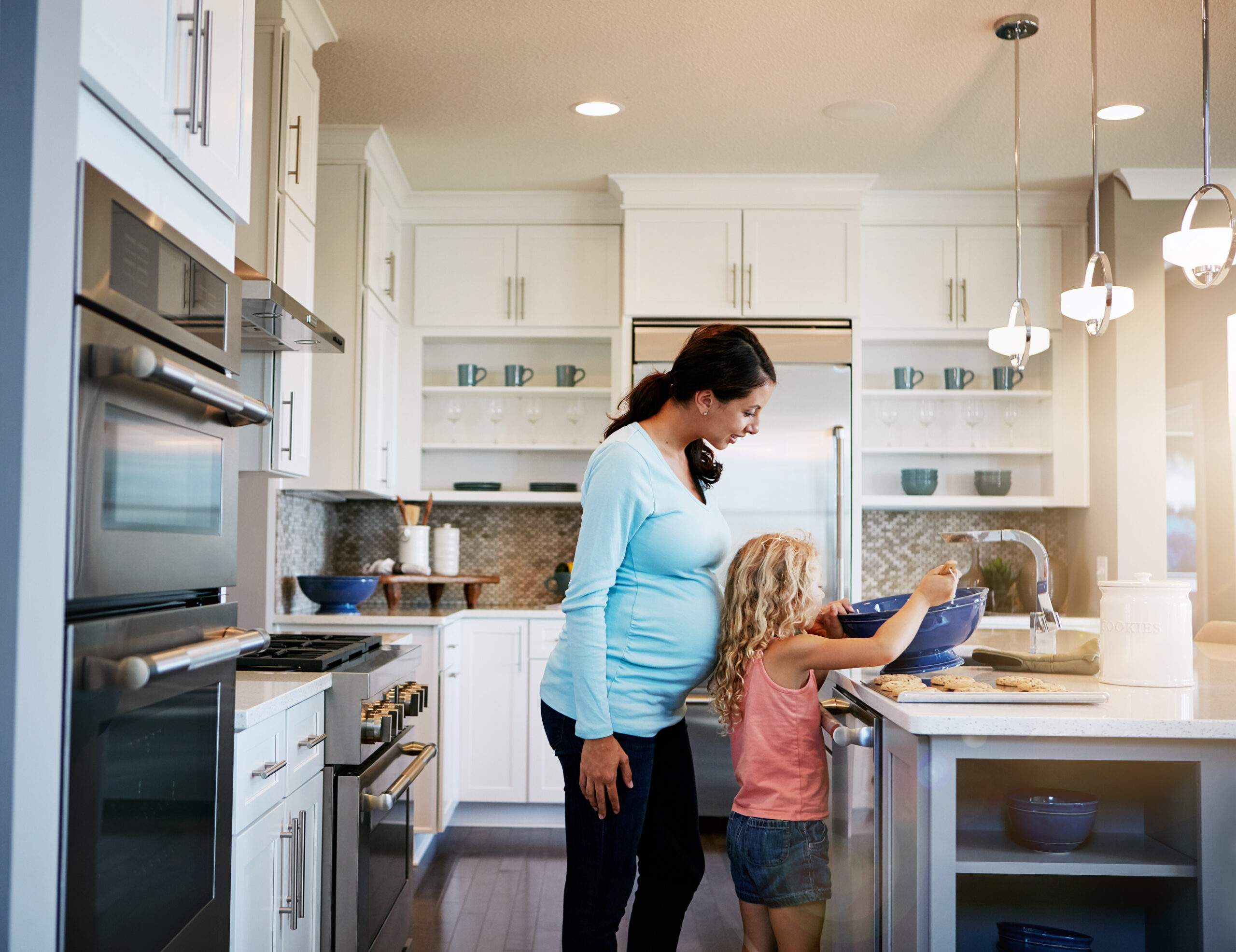 A daughter helping a mom to make sweet treats in the kitchen.